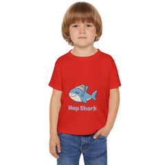Child wearing a red t-shirt with a blue shark graphic and 'Nap Shark' text on a white background