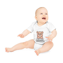 Baby wearing a white onesie with printed design on a white background