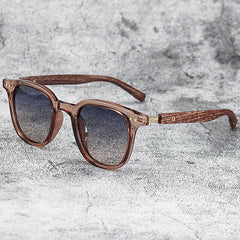 Wooden-framed sunglasses with dark lenses on a textured gray surface