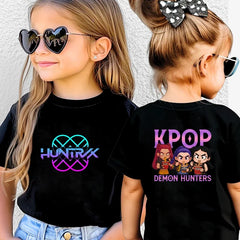 Two children wearing black t-shirts with colorful graphics and text.