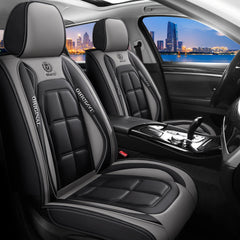 Car interior with black and gray seats featuring a brand logo, cityscape view outside.