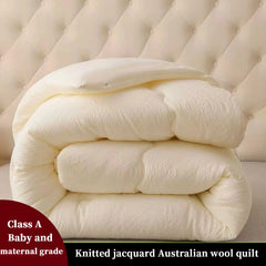 Knitted jacquard Australian wool quilt on a bed with a tufted headboard.
